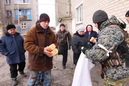 п.Красный Партизан перешел под контроль ополченцев ДНР. На снимке: ополченцы раздают местным жителям хлеб.