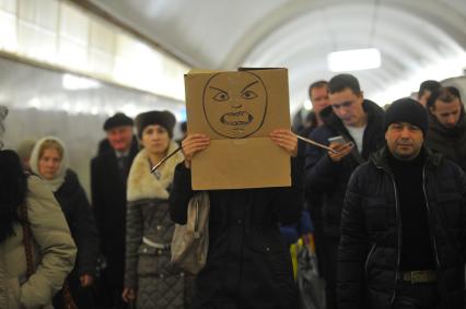 Девушка с коробкой на голове в московском метро.