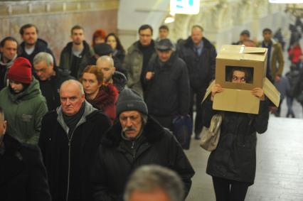 Девушка с коробкой на голове в московском метро.