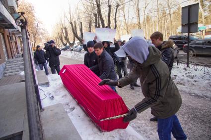 Активисты несут гроб к дверям офиса финансовой пирамиды МММ в Екатеринбурге, во время пикета против МММ