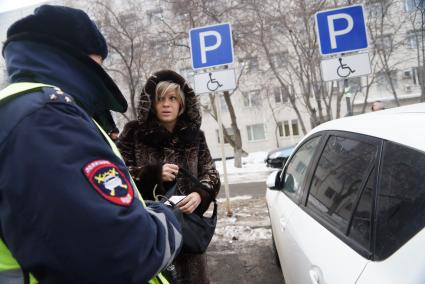 Сотрудник ДПС ГИБДД разговаривает с женщиной припарковавшей своя автомобиль на стоянке для инвалидов. Совместный рейд ГИБДД с инвалидами-автомобилистами \"За доступную парковку для людей с инвалидностью\". Министерства социальной политики г.Екатеринбург