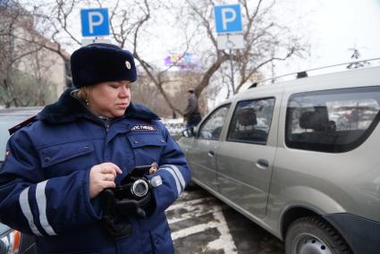 Сотррудник ДПС ГИБДД фиксирует нарушение правил парковки на месте для инвалидов. Совместный рейд ГИБДД с инвалидами-автомобилистами \"За доступную парковку для людей с инвалидностью\". Парковка у администрации г.Екатеринбург