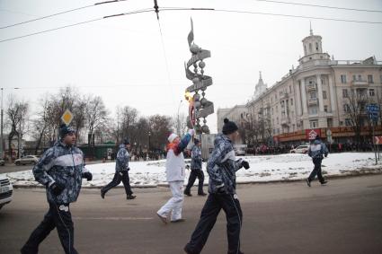 Участник эстафеты олимпийского огня пробегает мимо памятнику науке в ВОронеже