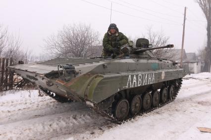 УУглегорск перешел под контроль подразделений ДНР. На снимке: ополченец едет на БМП с надписью `Лавина`.