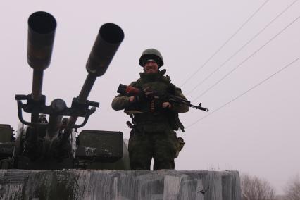 Углегорск перешел под контроль подразделений ДНР. На снимке: ополченец рядом с зенитным орудием.