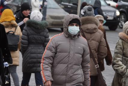 парень в медицинской маске дет по улице. Акция \"МАСКАрад\" в Екатеринбурге, в ходе которой горожанам раздавали маски, для снижения заболеваемости ОРВИ.