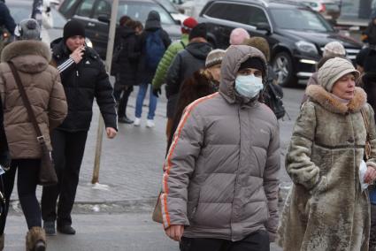 парень в медицинской маске дет по улице. Акция \"МАСКАрад\" в Екатеринбурге, в ходе которой горожанам раздавали маски, для снижения заболеваемости ОРВИ.