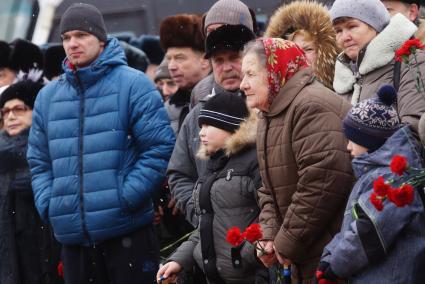 пожилая женщина держит букет гвоздик, во время вахты памяти войнов погибших в афганистане, у памятника войнам-интернационалистам \"Черный тюльпан\" в Екатеринбурге