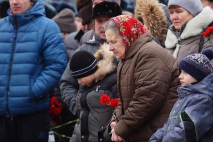 пожилая женщина держит букет гвоздик, во время вахты памяти войнов погибших в афганистане, у памятника войнам-интернационалистам \"Черный тюльпан\" в Екатеринбурге