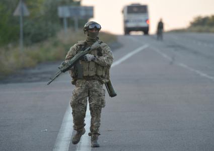 Донецкая область. Обмен военнопленными между ДНР и украинской стороной. На снимке: украинский военный с автоматом на трассе.