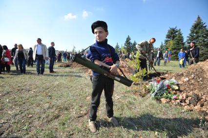 Украина. Донецкая область. Курган Саур-Могила. Похороны 17 ополченцев и захоронение останков 82 солдат Второй мировой войны. На снимке: мальчик с противотанковым оружием.