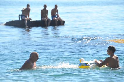 Алупка. Пляж. На снимке: мужчина с мальчиком купаются в море.