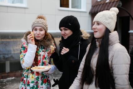 Ставропольские студенты-медики едят блины во время празднования Масленицы.