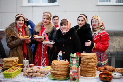 Ставропольские студенты-медики едят блины во время празднования Масленицы.