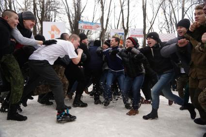 Молодые парни участвуют в народной забаве \"Стенка на стенку\". Празднование Масленицы в Харитоновском парке, в Екатеринбурге