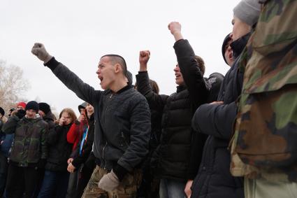 Молодые парни участвуют в народной забаве \"Стенка на стенку\". Празднование Масленицы в Харитоновском парке, в Екатеринбурге