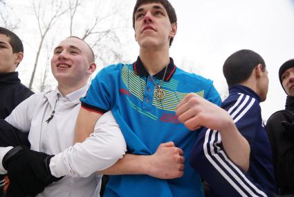 Молодые парни участвуют в народной забаве \"Стенка на стенку\". Празднование Масленицы в Харитоновском парке, в Екатеринбурге
