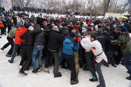 Молодые парни и мужчины участвуют в народной забаве \"Стенка на стенку\". Празднование Масленицы в Харитоновском парке, в Екатеринбурге