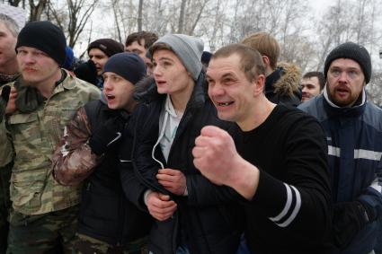 Молодые парни и мужчины участвуют в народной забаве \"Стенка на стенку\". Празднование Масленицы в Харитоновском парке, в Екатеринбурге