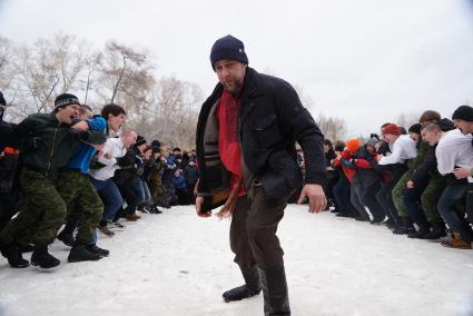 Молодые парни участвуют в народной забаве \"Стенка на стенку\". Празднование Масленицы в Харитоновском парке, в Екатеринбурге