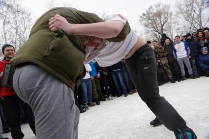 Молодые парни борятся перед участием в народной забаве стенка на стенку. Празднование Масленицы в Харитоновском парке, в Екатеринбурге