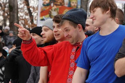 Молодые парни и мужчины участвуют в народной забаве \"Стенка на стенку\". Празднование Масленицы в Харитоновском парке, в Екатеринбурге