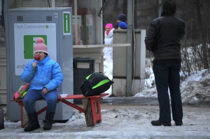 Москва. Парк `Сокольники`. Девочка ест глазированное яблоко.