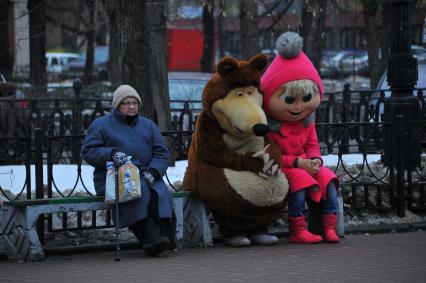 г.Москва. На лавочке сидят пожилая женщина и ростовые куклы Маша и Медведь.