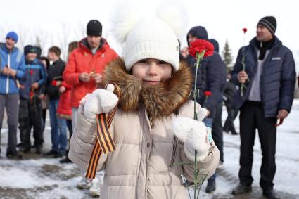 Саратов. Ребенок держит георгиевскую ленту и гвоздику во время церемонии возложения цветов к Вечному огню, приуроченной к 70-летию Победы в Великой Отечественной войне, в Парке Победы.