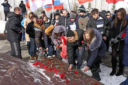 Саратов. Люди с цветами и флагами России и организации `Молодая Гвардия`во время церемонии возложения цветов к Вечному огню, приуроченной к 70-летию Победы в Великой Отечественной войне, в Парке Победы.