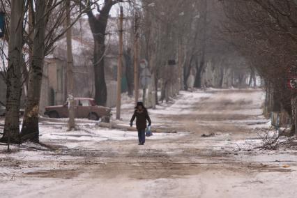 Украина. Донецкая область. г.Дебальцево. Местный житель с сумкой идет по дороге.