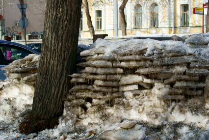 Дворники сложили стену из кусков снега с тротуара. Екатеринбург