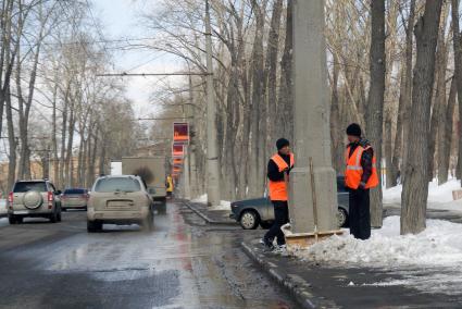 Дворники в оранжевых жилетках, отдыхают во время уборки снега вдоль дороги. Екатеринбург