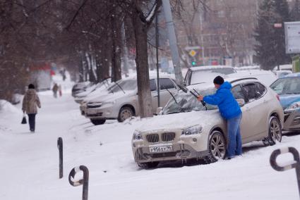 Водитель чистит от льда дворники, во время сильных заморозков. Екатеринбург
