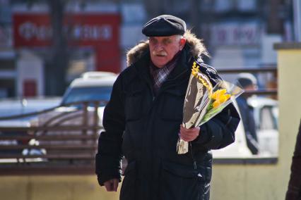 Воронеж. Подготовка в 8 марта. Мужчина с букетами мимоз и тюльпанов.