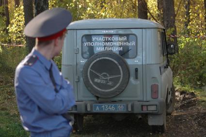 Полицейский в лесу у УАЗика участкового уполномоченного.