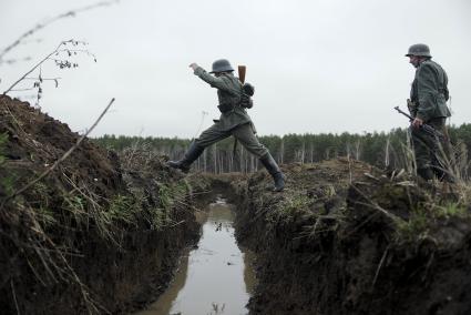 Екатеринбург. Военно-историческая реконструкция одного из боев по освобождению Белоруссии - `У деревни Буйничи`.
Немецкий солдат перепрыгивает окоп, заполненный водой.