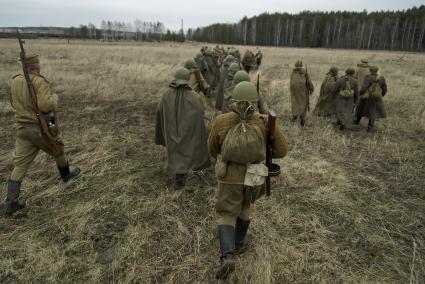 Екатеринбург. Военно-историческая реконструкция одного из боев по освобождению Белоруссии - `У деревни Буйничи`.
Бойцы Красной армии строем идут по полю.