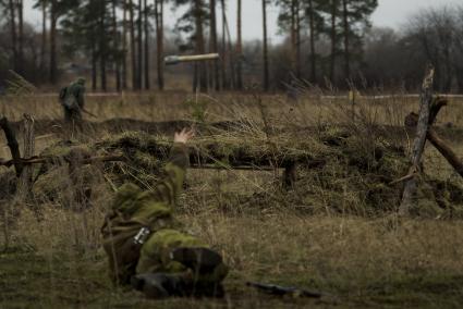 Екатеринбург. Военно-историческая реконструкция одного из боев по освобождению Белоруссии - `У деревни Буйничи`.
Боец Красной армии бросает гранату в окоп.