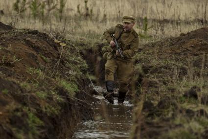 Екатеринбург. Военно-историческая реконструкция одного из боев по освобождению Белоруссии - `У деревни Буйничи`. Офицер Красной армии идет по окопу, заполненному водой.