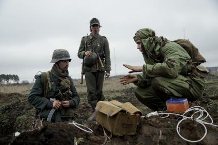 Екатеринбург. Военно-историческая реконструкция одного из боев по освобождению Белоруссии - `У деревни Буйничи`.
Участники реконструкции в форме немецких солдат разговаривают с пиротехником.