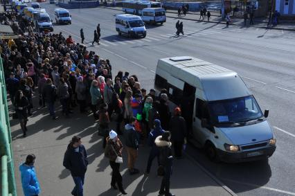 Люди стоят в очереди на маршрутку у станции метро `Выхино` в Москве.