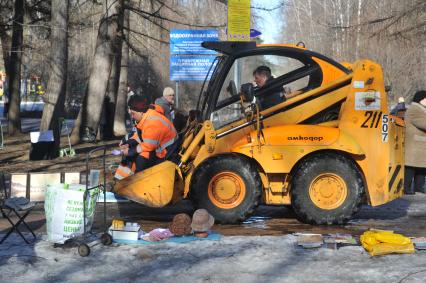 Москва. Парк `Кусково`.  Работники жилищно-коммунального хозяйства посыпает пешеходную зону песком.