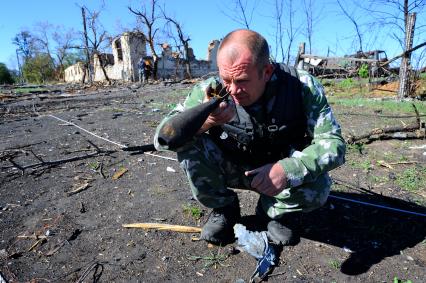 Украина. Донецкая область. с.Степановка. Командир минно-подрывного взвода с позывным `Валдай` осматривает мину.