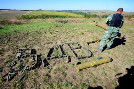 Украина. Донецкая область. с.Мариновка. Ополченец-сапер выложил на земле из патронов слово ВДВ.