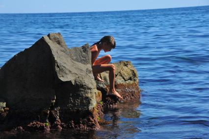 Алупка.  Девочка загорает на камнях.