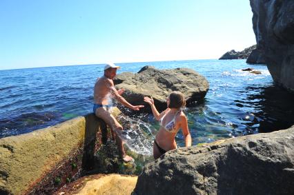 Алупка.  Парень и девушка загорают на камнях.