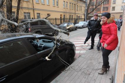 Дерево упавшее на машину в результате штормового ветра в Москве.