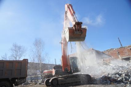 Екатеринбург. Принудительный снос незаконно построенного многоквартирного дома на земле для индивидуального строительства. Экскаватор собирает строительный мусор.