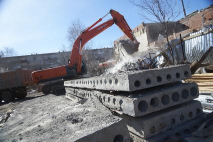 Екатеринбург. Принудительный снос незаконно построенного многоквартирного дома на земле для индивидуального строительства. Экскаватор собирает строительный мусор.